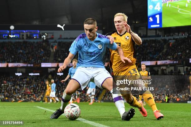 Manchester City's English defender Taylor Harwood-Bellis vies with Port Vale's English striker Mark Cullen during the English FA Cup third round...