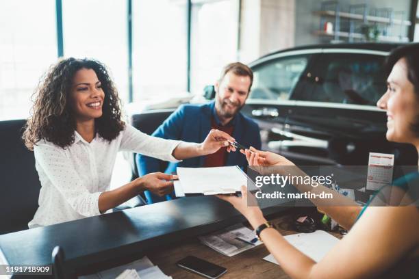 couple in the showroom buying new car - lease agreement stock pictures, royalty-free photos & images
