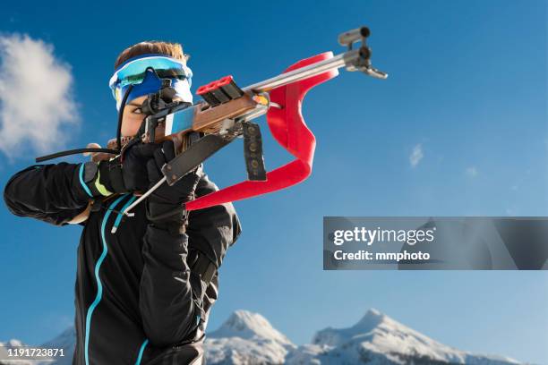 shot of young female biathlon competitor target shooting - biathlon ski stock pictures, royalty-free photos & images