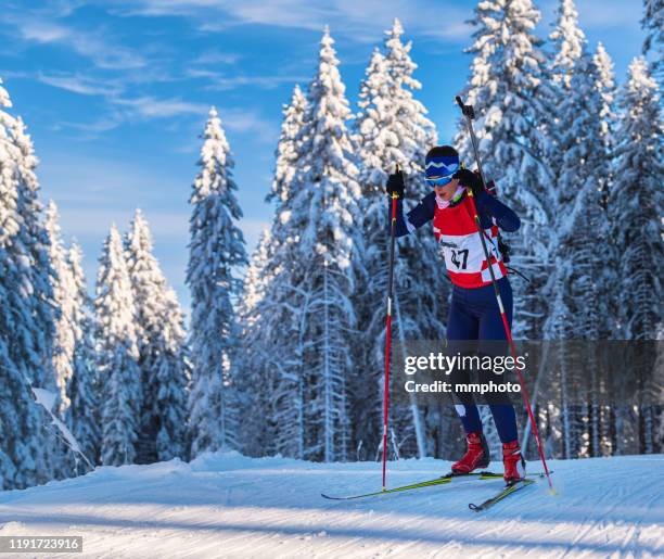 shot of young female biathlon competitor at cross country skiing - biathlon ski stock pictures, royalty-free photos & images