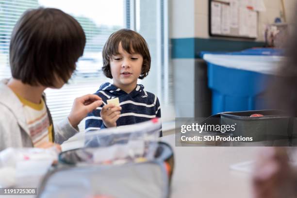 boys trade food during lunch - boy packlunch stock pictures, royalty-free photos & images