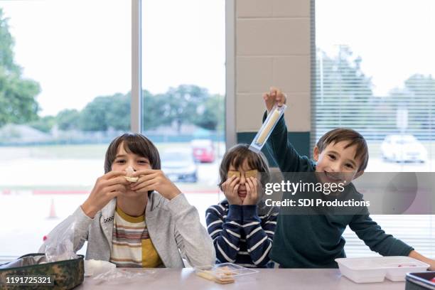 los niños juegan con la comida durante el almuerzo - barrita de queso fotografías e imágenes de stock