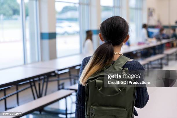 unrecognizable middle school girl walks timidly into cafeteria - brown hair girl stock pictures, royalty-free photos & images