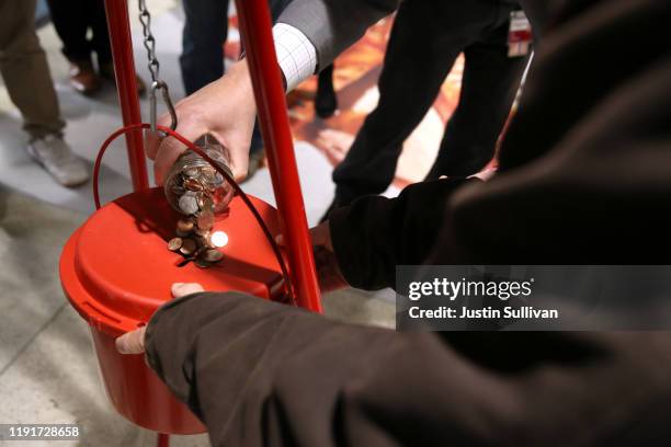 Board President Bevan Dufty pours change into a Salvation Army red kettle at the Powell Street Bay Area Rapid Transit station on December 03, 2019 in...