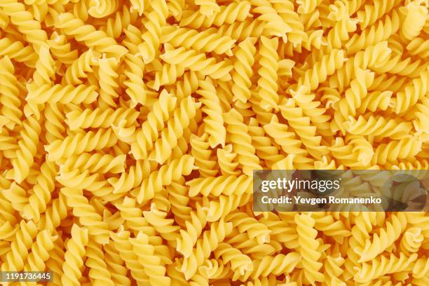 uncooked fusilli pasta background - pasta stockfoto's en -beelden