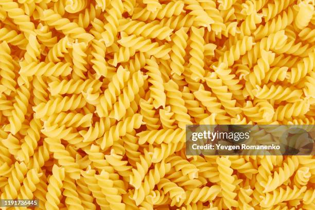 uncooked fusilli pasta background - fusilli stockfoto's en -beelden