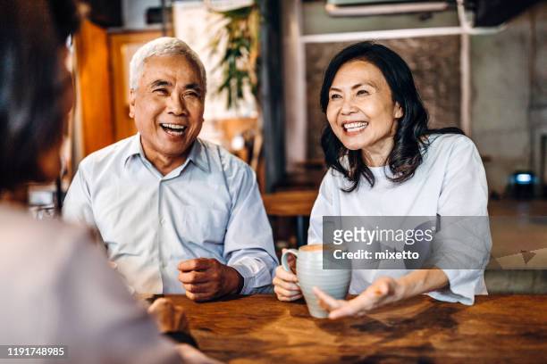 laughter and happiness is always present when get together - senior men cafe stock pictures, royalty-free photos & images