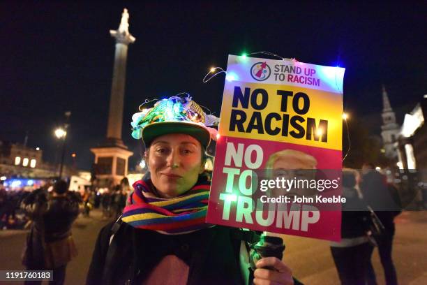 An anti Trump protester holds a placard saying "No to Racism and No to Trump" as NATO leaders attend Buckingham Palace Banquet at Trafalgar Square on...