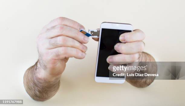hand inserting sim card in smartphone - all sim card stock pictures, royalty-free photos & images