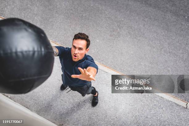 young caucasian male athlete doing medicine ball wall throw - medicine ball stock pictures, royalty-free photos & images