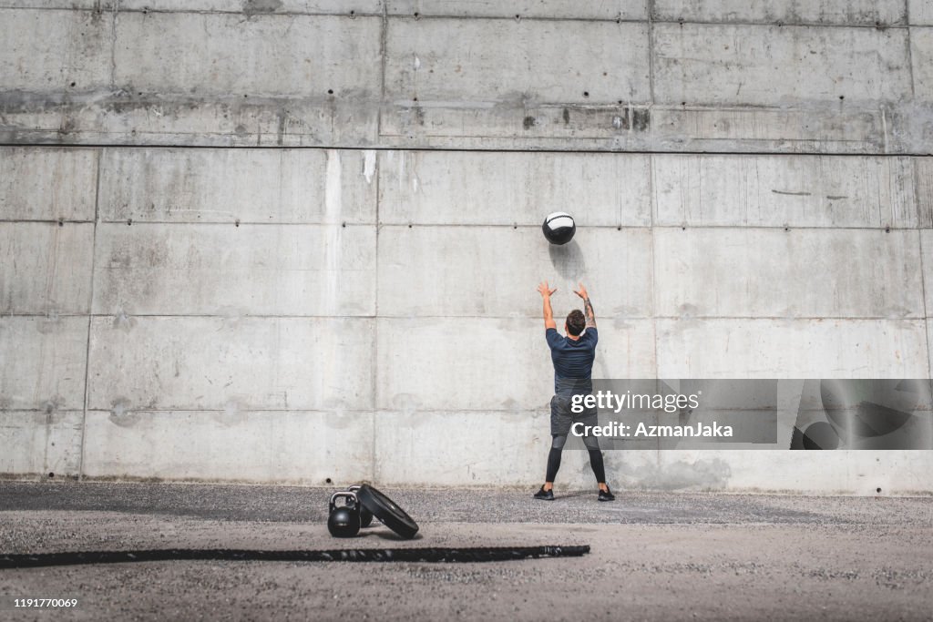 Male Athlete Exercising Outdoors with Medicine Ball