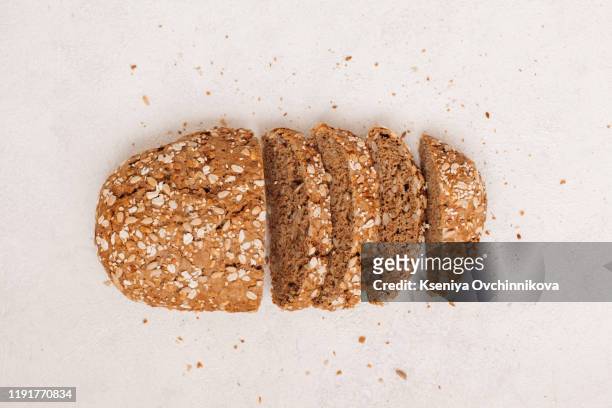 top view of sliced wholegrain bread on dark ructic wooden background closeup - rogge graan stockfoto's en -beelden