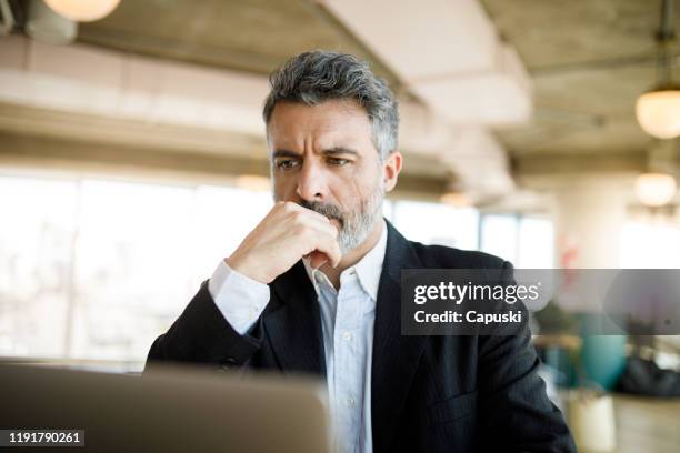 concentrated businessman with hand on chin - man check suit stock pictures, royalty-free photos & images