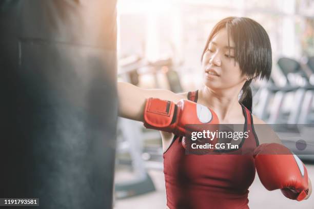 An Asian Chinese Female Teenager Athlete Wearing Boxing Gloves Workout In Gym During Weekend High-Res Stock Photo