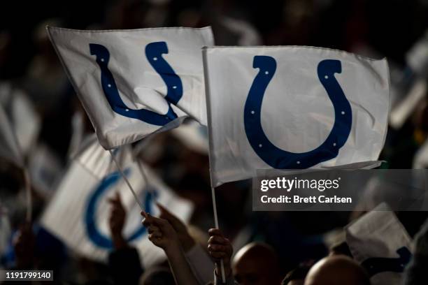 Indianapolis Colts fans wave flags bearing the team"u2019s logo before the game against the Tennessee Titans at Lucas Oil Stadium on December 1, 2019...