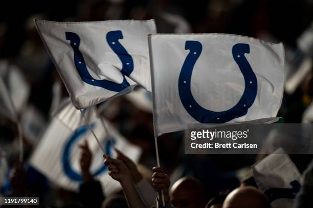 Indianapolis Colts fans wave flags bearing the team"u2019s logo before the game against the Tennessee Titans at Lucas Oil Stadium on December 1, 2019...