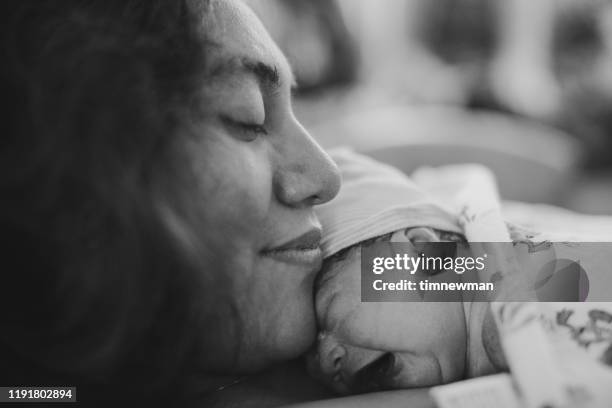 moeder en pasgeboren baby in ziekenhuis bed bonding - moms crying in bed stockfoto's en -beelden