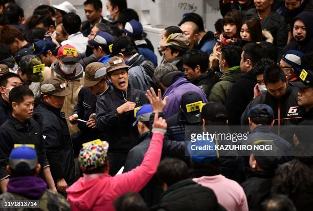 Wholesalers participate in the New Year's auction at Tokyo's Toyosu fish market on January 5, 2020. - Kiyomura Corp., the Tokyo-based operator of...