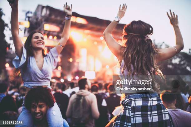 carefree women and their boyfriends having fun on a music concert. - carrying on shoulders stock pictures, royalty-free photos & images