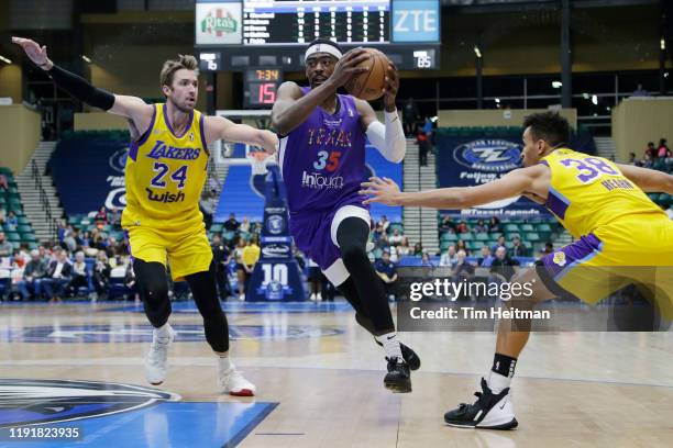 Aric Holman of the Texas Legends drives on Travis Wear of the South Bay Lakers and Reggie Hearn of the South Bay Lakers in the third quarter on...