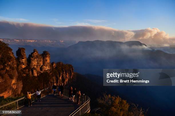 People view smoke from scattered bush fires on a look out platform that over looks the Three Sisters on December 04, 2019 in Katoomba, Australia. It...