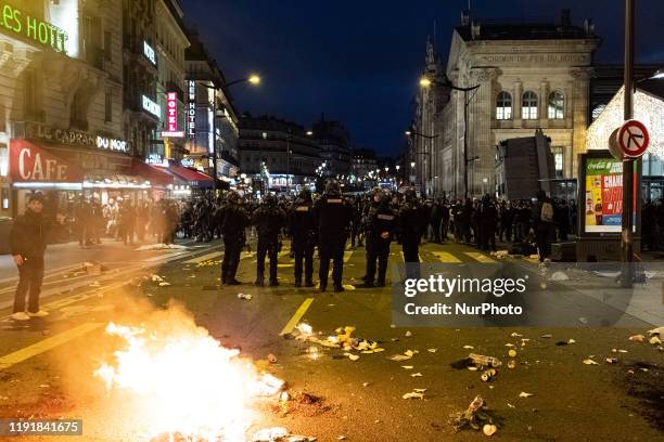 Outside the Gare du Nord train station, demonstrators and Gilets Jaunes set fire to garbage cans across the road before being pushed back by riot...