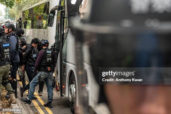 Detained protesters are being escorted on to a coach bus by riot ...