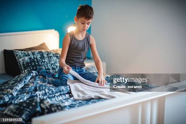 boy folding his clothes - sweatshirt stock pictures, royalty-free photos & images
