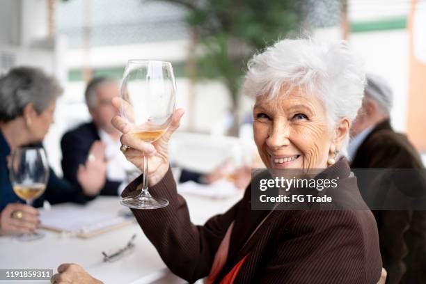 ritratto di donne anziane sorridenti che tengono un bicchiere di vino - happy hour foto e immagini stock