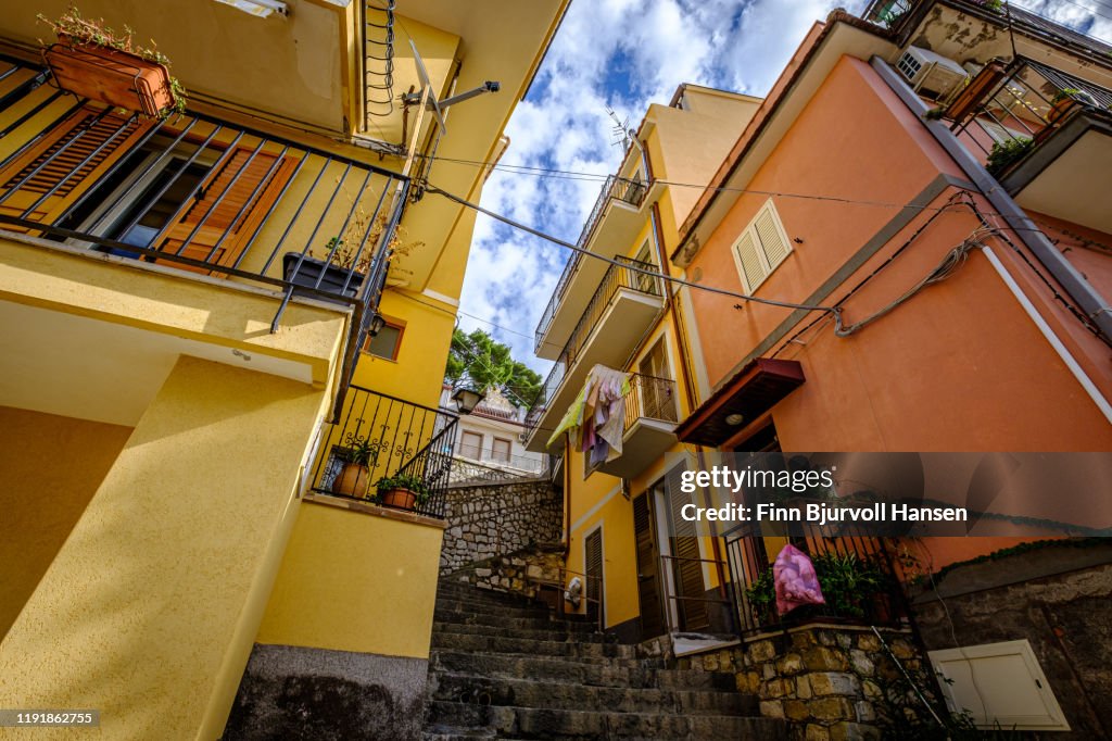 Stairs and buildings in Castelmola Taormina Sicily - laundry and garbage hanging from balcony