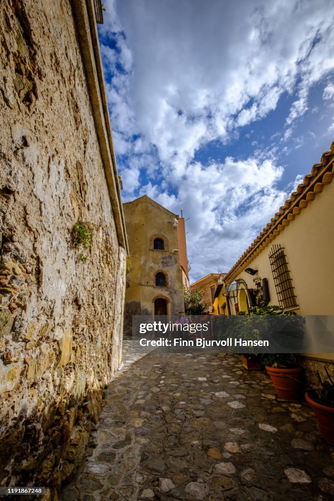 Narrow alley and old houses with plants outside in Castelmola Taormina Sicily Italy