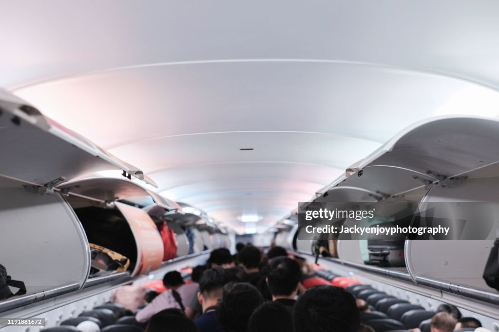 Overhead locker on airplane,Passenger put cabin bag cabin on the top shelf. Travel concept