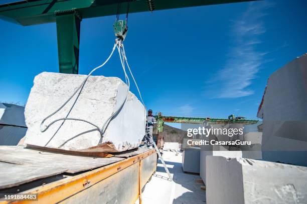 picking up block shape marble stone with crane from truck trailer - natural stone block stock pictures, royalty-free photos & images