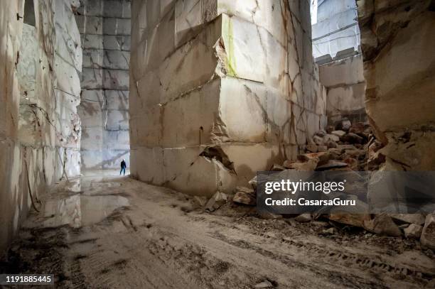 採石場の人工地下トンネルに立つ成人男性 - marble quarry ストックフォトと画像