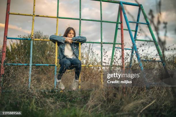 tiener meisje op oude verlaten speeltuin - verlaten slechte staat stockfoto's en -beelden