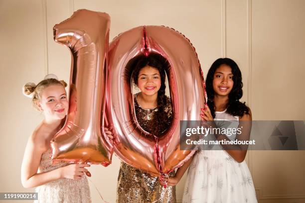 cute young girls holding balloons for 10th birthday. - cocktail dress stock pictures, royalty-free photos & images