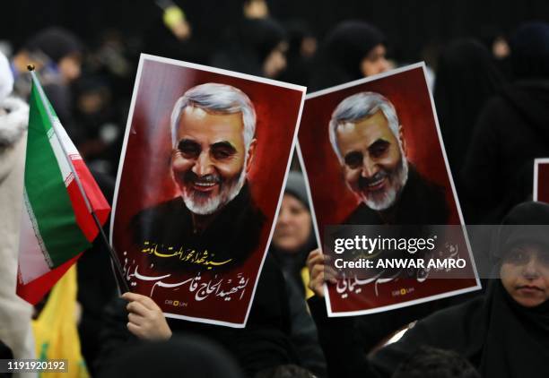 Supporters of Shiite Hezbollah movement hold posters of slain Iranian major general Qasem Soleimani as the movement's leader delivers a speech on a...