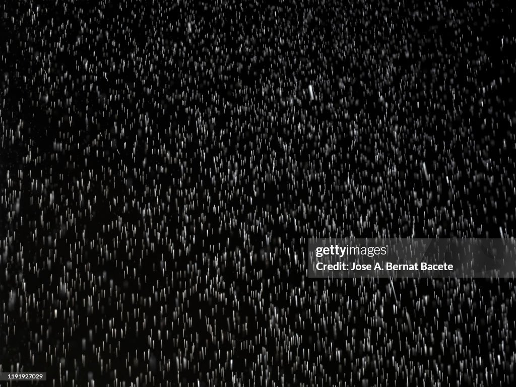 Full frame of Raindrops falling on a black background.