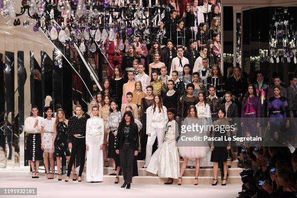 Models and Designer Virginie Viard pose on the runway during the Chanel Metiers d'art 2019-2020 show at Le Grand Palais on December 04, 2019 in...
