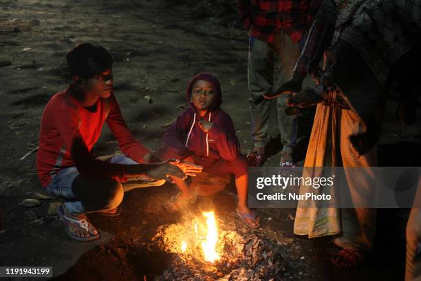 People make fire to keep them warm during winter near the river Buriganga in Dhaka , Bangladesh on 05 January 2020.