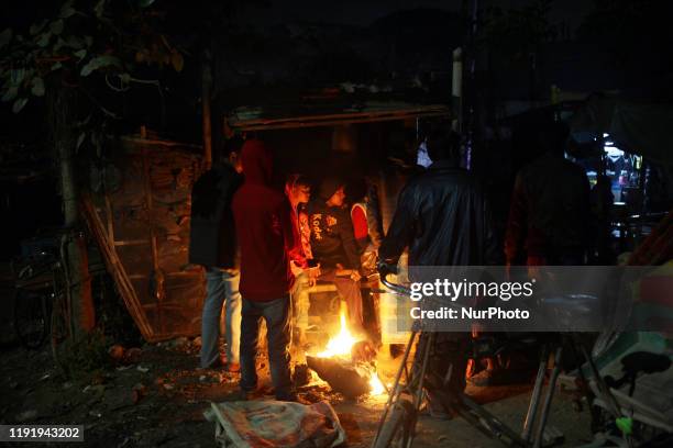 People make fire to keep them warm during winter near the river Buriganga in Dhaka , Bangladesh on 05 January 2020.