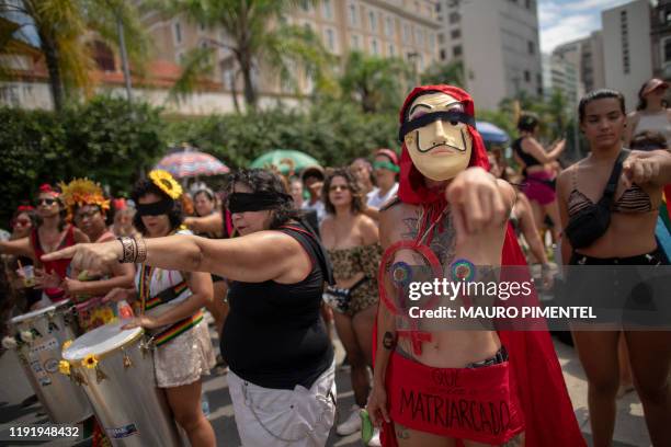 Revellers of the street carnival group Mulheres Rodadas perform the feminist flash-mob song "The Rapist is You!", a Chilean creation that went...