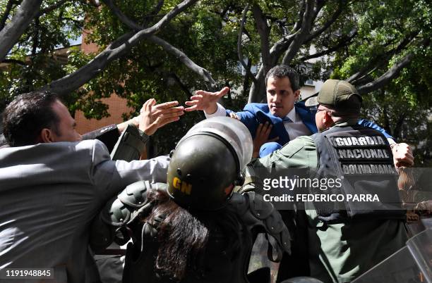 Venezuelan opposition leader and self-proclaimed acting president Juan Guaido is blocked by security forces as he tries to reach the National...