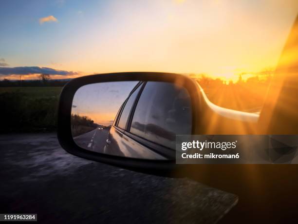 view of a car wing mirror. sunset time - autoglas stock-fotos und bilder