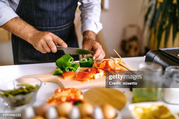 onherkenbaar man snijden groene paprika - hand with bell stockfoto's en -beelden