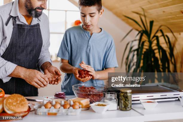 dinner preparation of father and son - boy cooking stock pictures, royalty-free photos & images