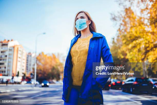 vrouw dragen gezichtsmasker vanwege vervuiling - operatiemasker stockfoto's en -beelden