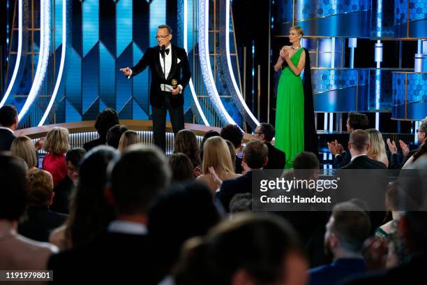 In this handout photo provided by NBCUniversal Media, LLC, Tom Hanks accepts the CECIL B. DEMILLE AWARD, presented by Charlize Theron, onstage during...