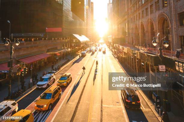 manhattanhenge on the streets of new york city - new york city sunrise stock pictures, royalty-free photos & images