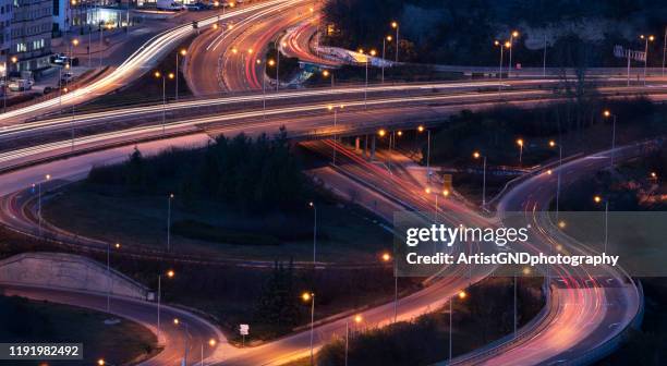 traffic on the intersection during the night - elevated road stock pictures, royalty-free photos & images